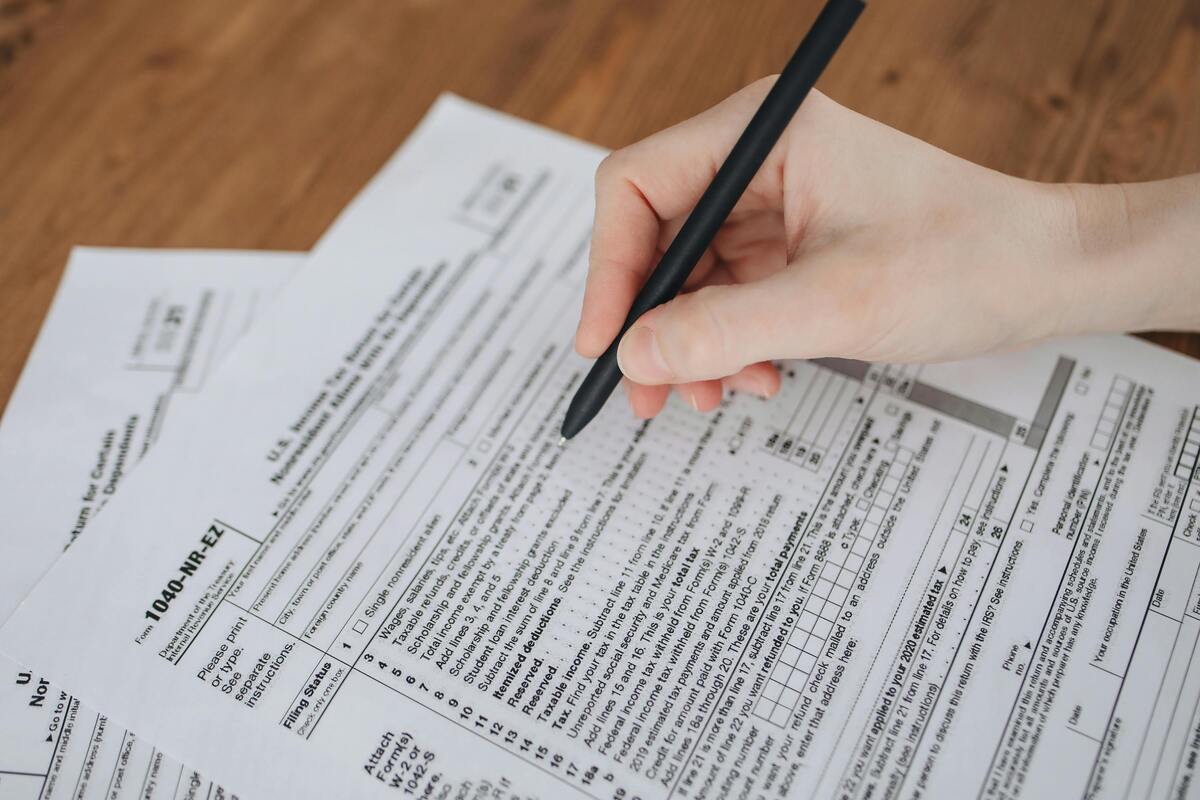 Hand reviewing printed forms with a pen representing Enlaze Communications’ immigration case preparation support for U.S. law firms.