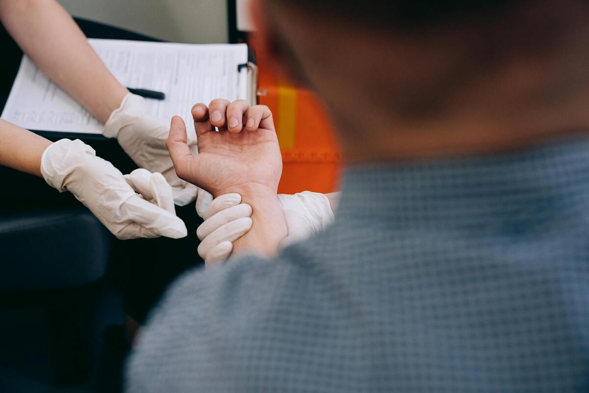 Medical professional examining a patient’s wrist representing Enlaze Communications’ support services for personal injury law firms managing client communication, records, and case follow-up.