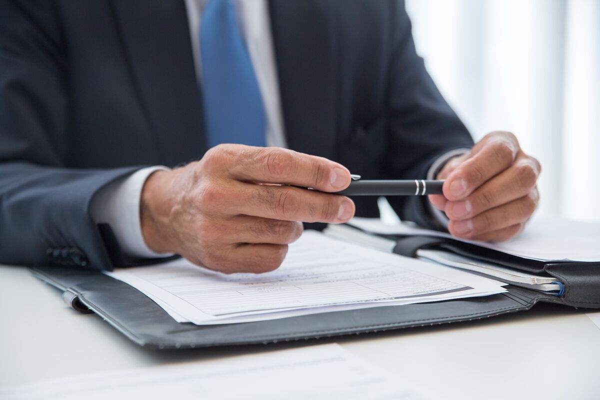 Law firm professional reviewing case documents with a pen, representing virtual legal assistant support for case managers who need help staying organized