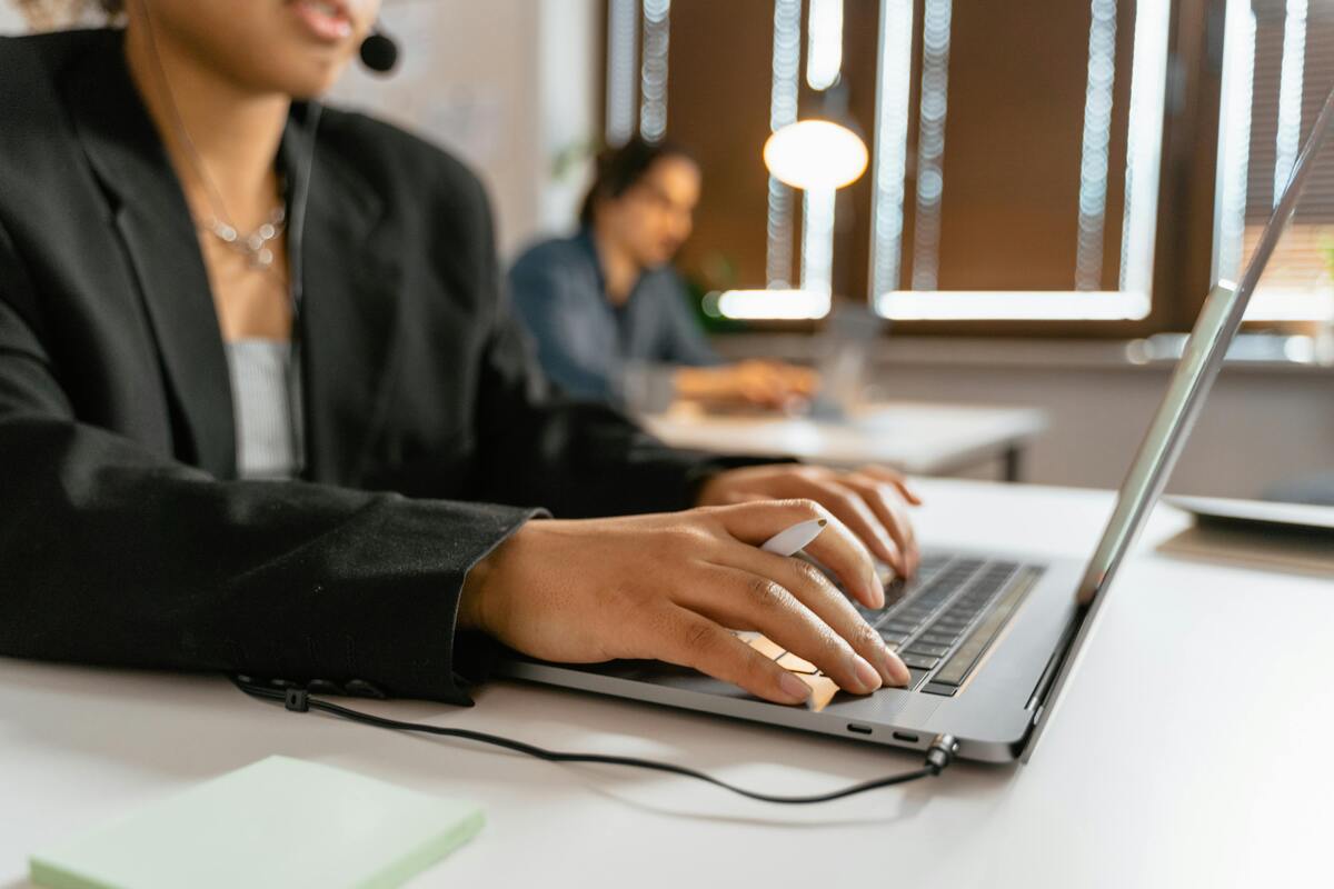 Support professional wearing a headset while working on a laptop, representing virtual legal assistant support for hiring teams that need legal help without a long hiring cycle