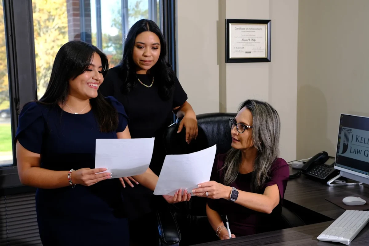 Attorney Johanna Kelley and her team reviewing documents together in a professional office at Enlaze Communications