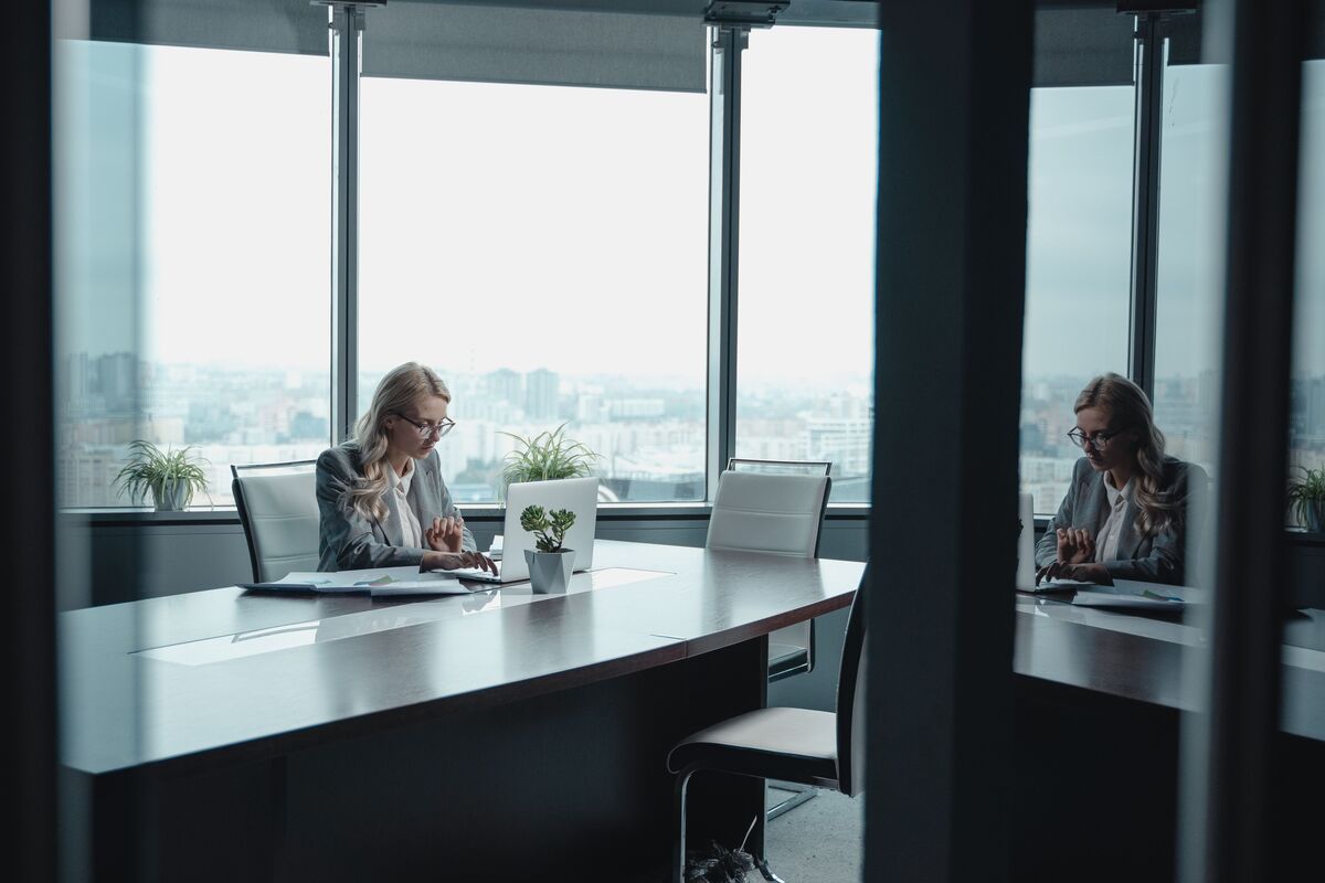 Woman working on a laptop in a modern conference room, illustrating law firm outsourcing services