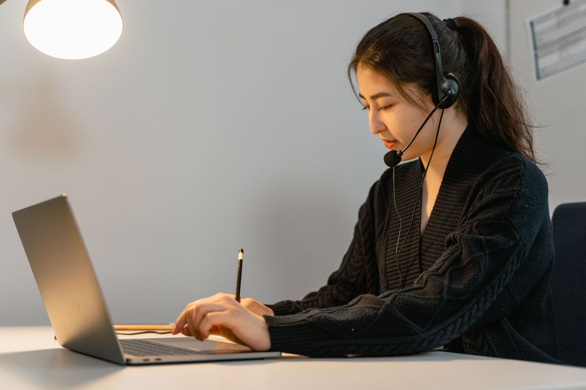 Virtual administrative assistant for law firms working at a laptop with a headset.